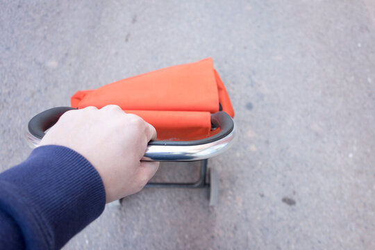 Man Pushing An Orange Shopping Cart