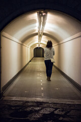 woman walking through an underground tunnel