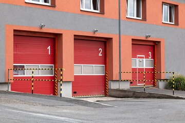 Red entrance gates to a fire station where the fire trucks are parked and ready for emergency...