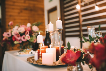 Obraz na płótnie Canvas Wedding, decor on the table, candles are burning, a bouquet of flowers. Rustic wood background...