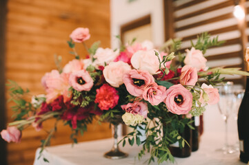 Wedding, decor on the table, candles are burning, a bouquet of flowers. Rustic wood background...