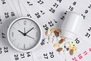 Control Time to take pills. Clock with a bottle of pills on a monthly calendar