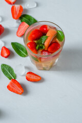 glass mix cocktail strawberry, lime, grapefruit. on the table pieces of strawberries, mint, ice.Isolated.High quality photo