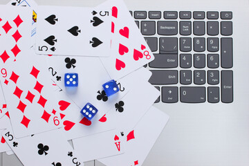 Playing Cards and Blue Dice on a laptop keyboard. Online poker casino