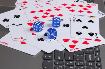 Playing Cards and Blue Dice on a laptop keyboard. Online poker casino
