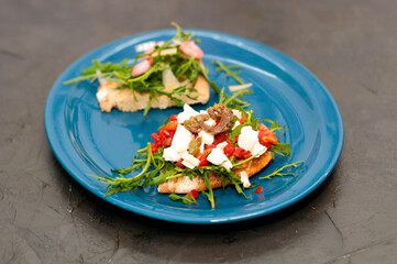 Bruschetta with shrimp, arugula, tomatoes, cheese and sauce. High Italian cuisine