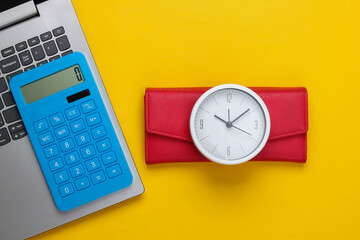 Time to make money. Online business. White clock, laptop, calculator and red wallet on yellow background. Top view. Flat lay