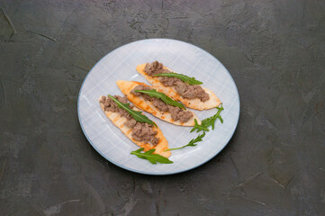 Croutons with paste and arugula. Festive snack New Year Italian dish. Top view, copy space.