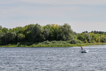 Fototapeta na wymiar Rescuers on the river in a motor boat in the summer in Belarus.
