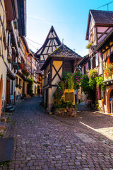 Eguisheim a village in Alsace in France, old architecture, flowers on the windows and colored facades