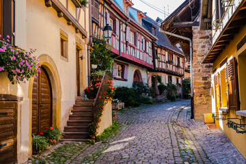 Fototapeta na wymiar Eguisheim a village in Alsace in France, old architecture, flowers on the windows and colored facades