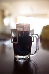 Instant freshly brewed cup of coffee or paper dripping bag on a cup.