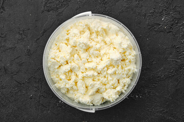 Top view of homemade cottage cheese in plastic bowl