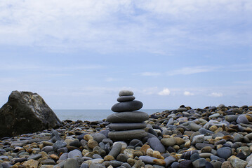 Pyramid of round stones on the seashore, the concept of harmony, balance and meditation.