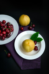 Peaches and cherries on a white dinner plate