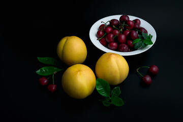 Peaches and cherries on a white dinner plate