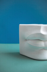  white statue of lips on blue and green background
