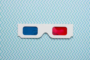 Stereoscopic anaglyph disposable paper 3d glasses on blue background. Top view