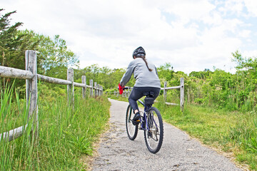 A woman rides her bicycle along a woodland path in Fairhaven, Massachusetts.