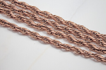 Fototapeta premium Decorative and jewelry gold chain close-up on a white background. Fashionable large chain