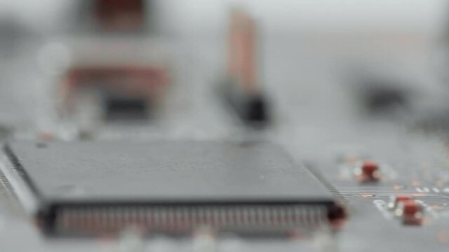 Printed circuit board with electrical components, electrolytic capacitors, resistors, transistors, integrated microchips, chips. Macro of sound audio internal expansion card, surface-mount technology