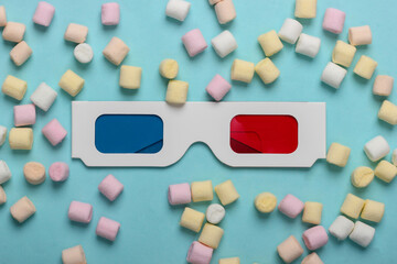Anaglyph disposable paper 3d glasses with marshmallows on a blue background. Pop art, minimalism