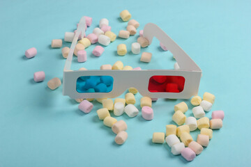 Anaglyph disposable paper 3d glasses with marshmallows on a blue background. Pop art, minimalism