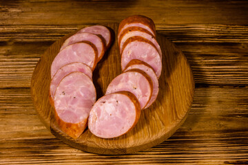 Cutting board with sliced sausage on a wooden table