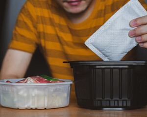 Man cooking self heating hot pot can order to home delivery ready to eat by heat from self heating...