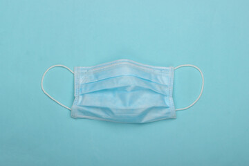 Facial medical mask on a blue background. Top view
