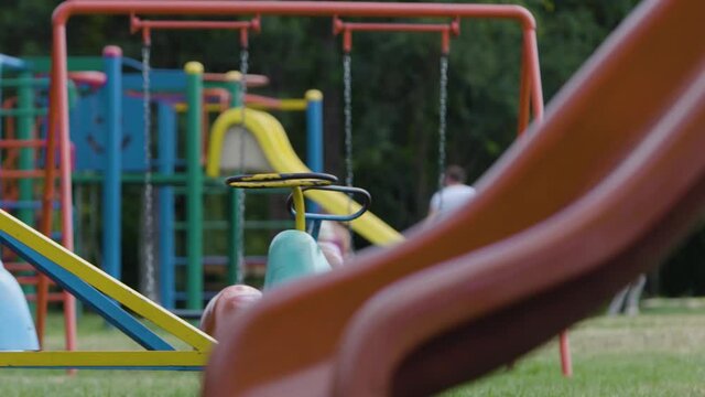 Empty merry-go-round spinning by itself in a children playground