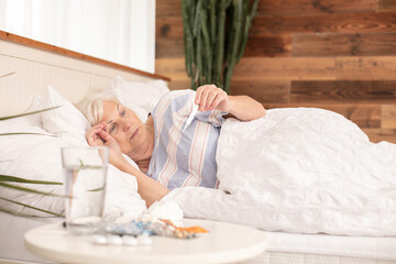 Obraz na płótnie Canvas Sick senior woman in bed, at home.