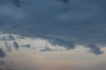 Obraz premium Beautiful dramatic gray and white clouds on blue sky, variety of shapes, silhouettes and shades at sunset time