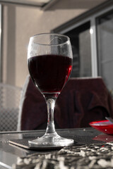 glass of delicious red wine with sun reflection on the glas and black and white feeling except of red colour