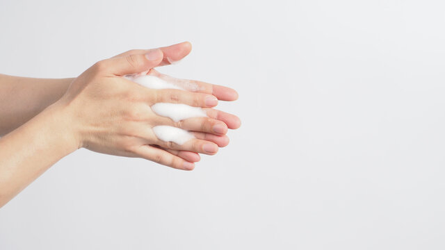 Hands washing gesture with foaming hand soap on white background.