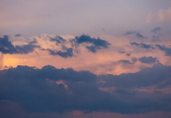 Beautiful dramatic gray and white clouds on blue sky, variety of shapes, silhouettes and shades at sunset time