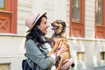 young attractive woman playing with her dog on the city street, lifestyle people concept. Beauty...