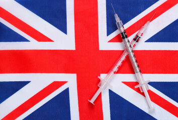 Fototapeta premium Syringes with the flag of Great Britain. Vaccination. Pandemic covid-19