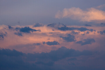 Beautiful dramatic gray and white clouds on blue sky, variety of shapes, silhouettes and shades at sunset time