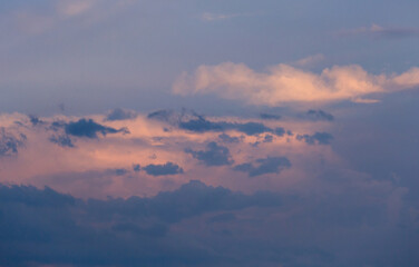 Beautiful dramatic gray and white clouds on blue sky, variety of shapes, silhouettes and shades at sunset time