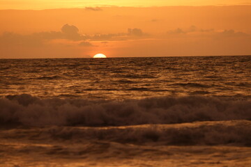 A beautiful sunset . The sun throwing its reds and oranges into the sky like a molten lava.