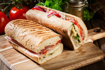 Toasted panini with ham, cheese and arugula sandwich - 354607579