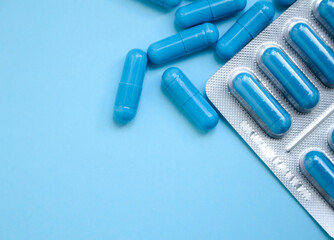 Blue capsules on a blue background. Flatlay, layout, copyspace. blister with blue capsules, world pharmacist's day 