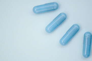 Blue capsules on a blue background. Flatlay, layout, copyspace.