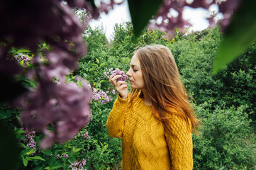 Outdoor fashion photo of beautiful young woman surrounded by flowers. Spring blossom