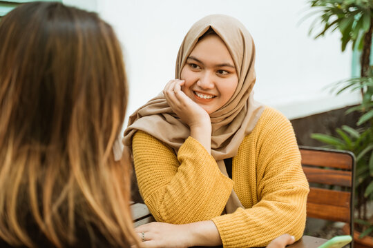 hijab girls see friends while sitting chatting in a cafe in their spare time