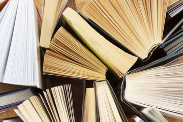 Naklejka premium Books Stacked in Pile. Lots of Book Edges with Yellow and White Pages and Hard and Soft Book Covers, Abstract Background. Concept for Studying and Education