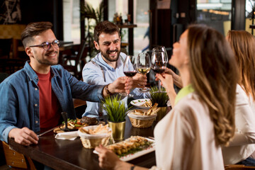 Group of young people having dinner in the restaurant