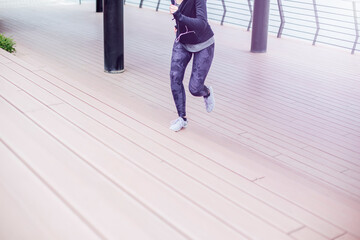 Young woman runing on the stairs and listening the music