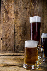 Different sorts of craft beer on wooden bar background. Set of various beer glasses and mugs. Beer tasting concept